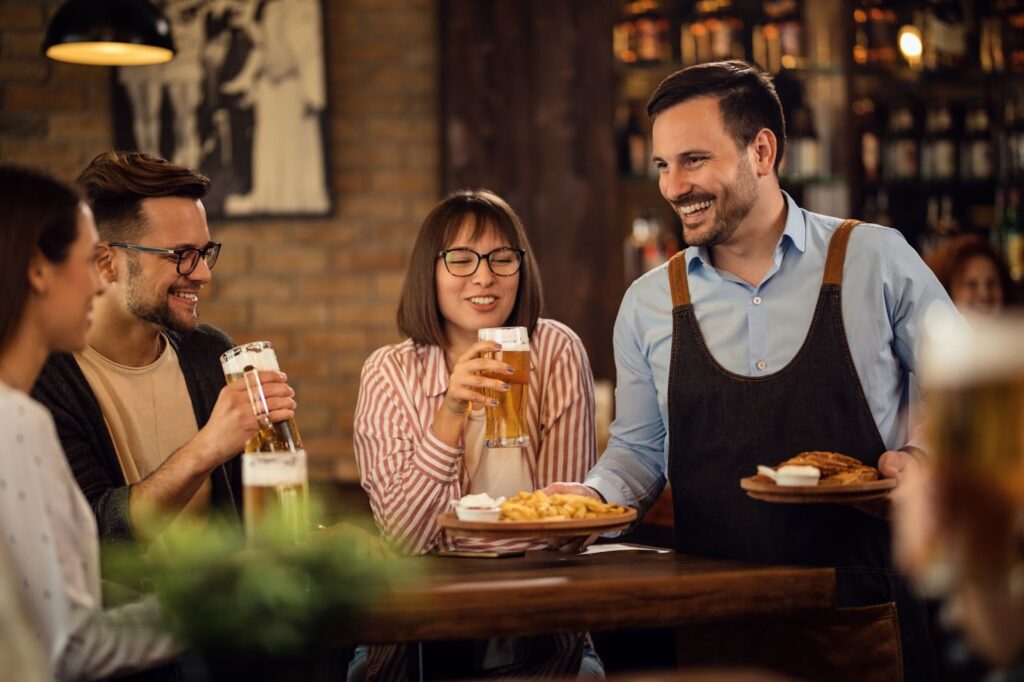 Waiter is serving food to group of people