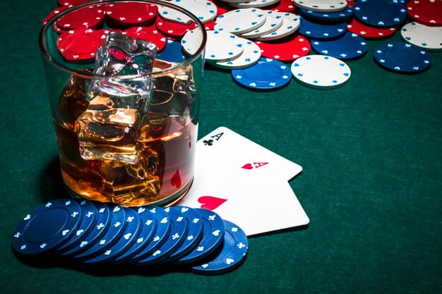 Whisky Glass with Ice over the Gambling Table