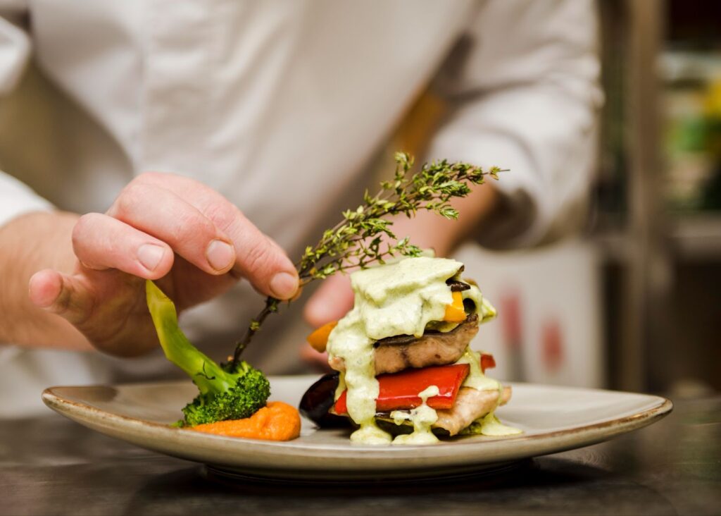 Chef placing herb on gourmet meal
